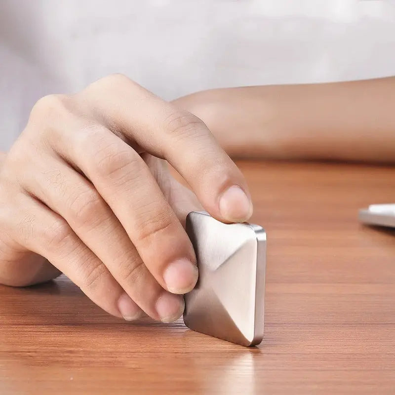 HexFlip metal fidget toy in silver being flipped on wooden desk surface - stress relief and focus tool demonstration