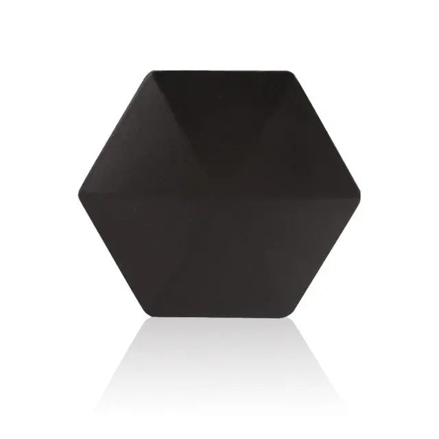 HexFlip metal fidget toy in sleek black hexagonal design with matte finish on reflective surface - stress relief gadget