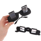 HighPeak Lazy Glasses in black held in hand showing prism lenses designed for comfortable screen viewing while lying flat
