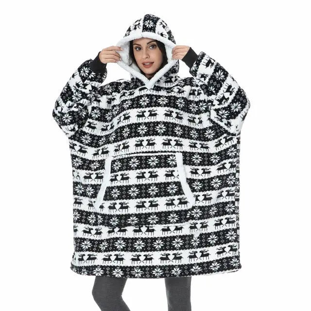 Oversized Hoodie Blanket in black and white Nordic reindeer pattern with sherpa lining and front pocket demonstrated on cozy winter wear