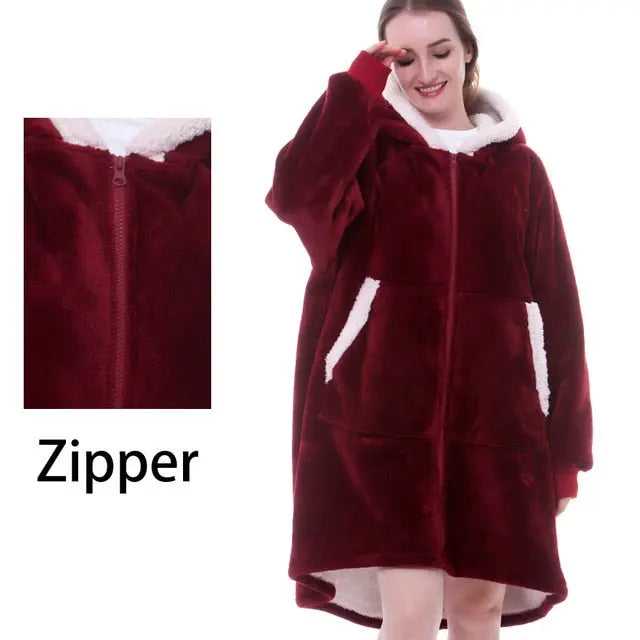 Oversized Hoodie Blanket in burgundy red with white sherpa lining, front zipper and kangaroo pockets shown on lifestyle model