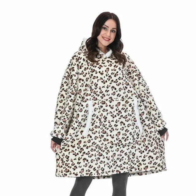 Oversized Hoodie Blanket in leopard print pattern worn by model, showcasing cozy sherpa-lined design with front pocket and hood