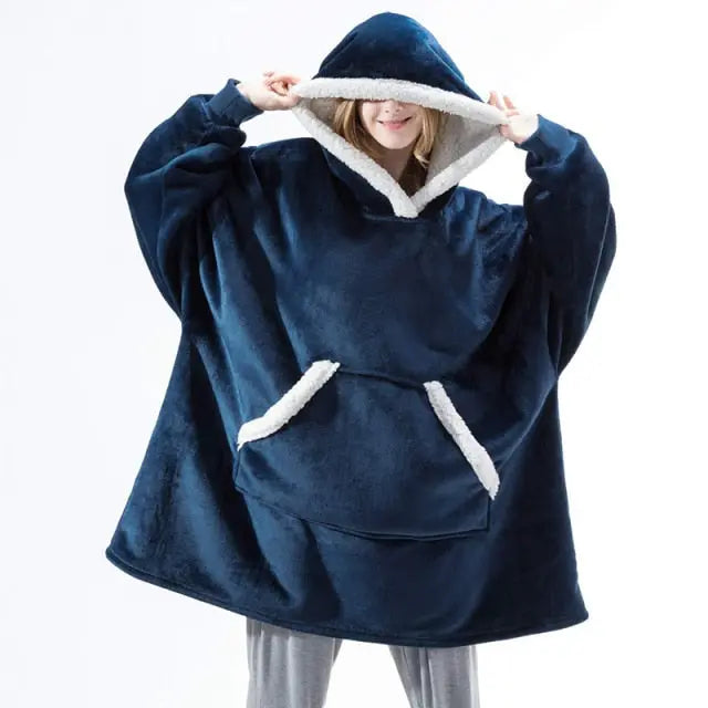 Oversized Hoodie Blanket in navy blue with sherpa lining and kangaroo pocket, shown on model against white background