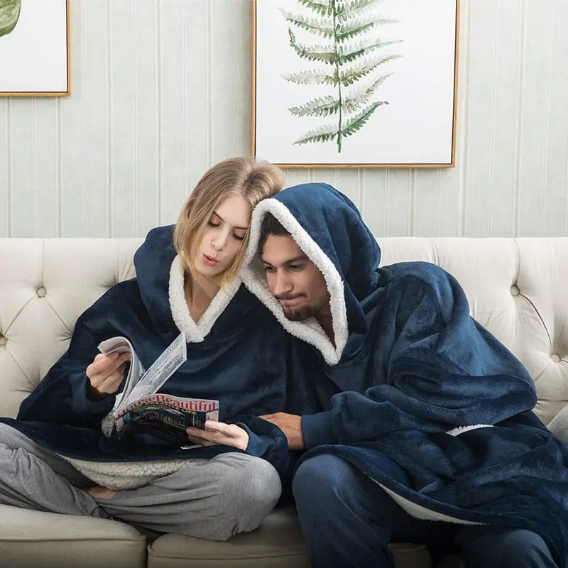 Oversized Hoodie Blanket in navy blue with sherpa lining shown on couch, perfect for cozy lounging and relaxation