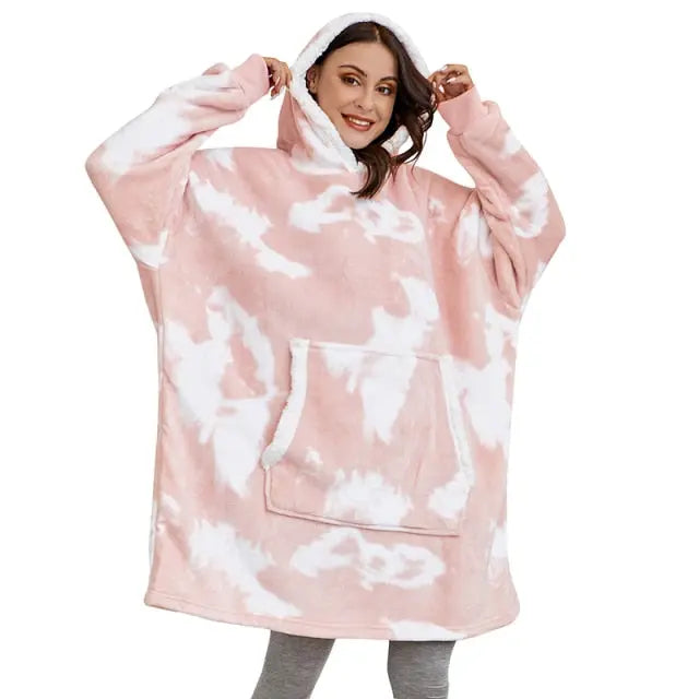 Oversized Hoodie Blanket in pink and white tie-dye pattern with kangaroo pocket and cozy sherpa-lined hood, shown in casual wear
